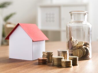 miniaturbank-mit-munzstapeln-und-glas-daneben